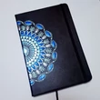 Fekete borítójú, pontfestett mandalás jegyzetfüzet fehér gyöngyvirág mintával.