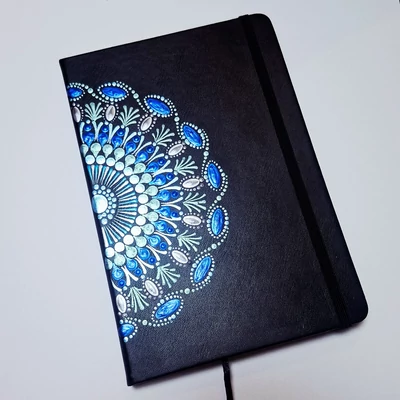 Fekete borítójú, pontfestett mandalás jegyzetfüzet fehér gyöngyvirág mintával.